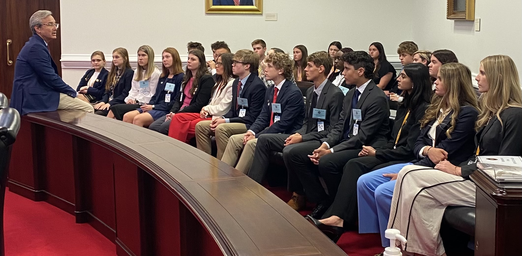 Pages seated in Senate chamber listening to a Senator speaking before them